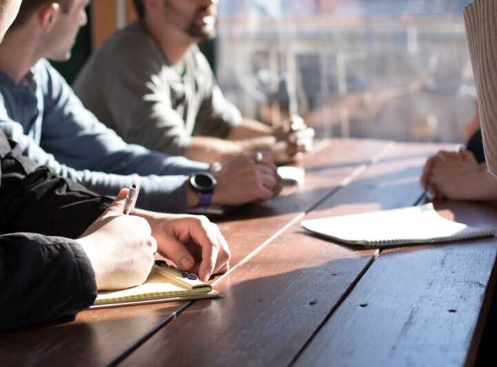 Discussion around a table with notepads and pens